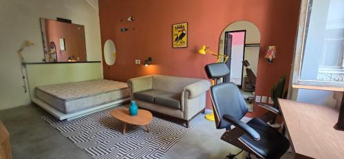 uma sala de estar com um sofá e uma cadeira em Castelo dos Tucanos Host no Rio de Janeiro