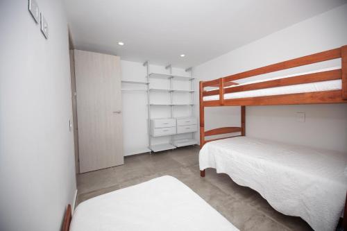 a bedroom with two beds and a bunk bed at Apartamento Torres Sunrise Beach in San Andrés