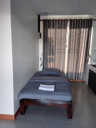 a bed sitting in a room with a window at Huan Janto Homestay - Metta in Chiang Mai