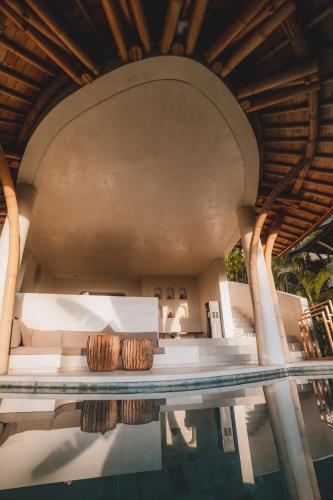 a pool at a resort with two baskets on a table at Mambo Lombok in Kuta Lombok