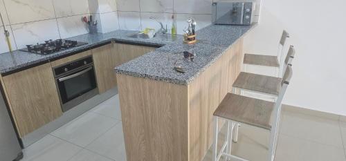 eine Küche mit einer Arbeitsfläche, die mit einem Spülbecken und einem Herd ausgestattet ist in der Unterkunft Residence fedi in Monastir