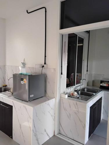 a kitchen with white marble counters and a sink at Huan Janto Homestay - Metta in Chiang Mai