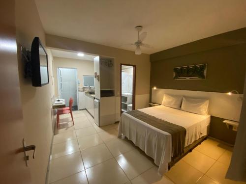 une chambre d'hôtel avec un lit et une cuisine dans l'établissement Residencial Lúpulos, à Angra dos Reis