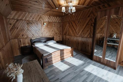 a bedroom with a bed in a wooden room at Sadyba u Halyny in Bukovel