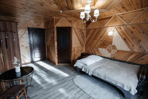 a bedroom with a bed in a wooden room at Sadyba u Halyny in Bukovel