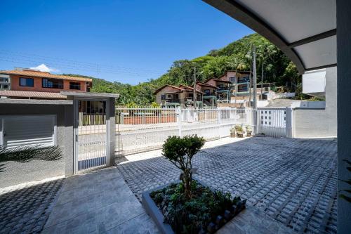 uma árvore em vaso sobre uma calçada de tijolos em Seu Paraíso em Bombinhas Apto Totalmente Equipado a 3 Minutos da Areia em Bombinhas