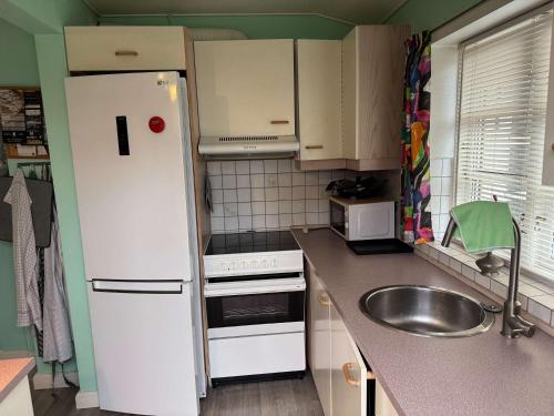 een keuken met een witte koelkast en een spoelbak bij Summerhouse in Liseleje in Liseleje