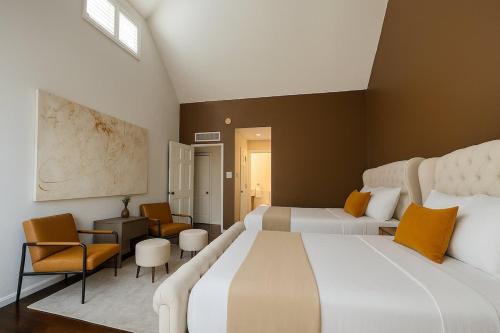 une chambre d'hôtel avec deux lits et une chaise dans l'établissement Huge Ceilings Pool Piano ART, à Dallas