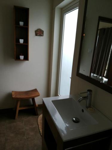 a bathroom with a sink and a mirror and a stool at Villa Fair Shares 1 in Poste Lafayette