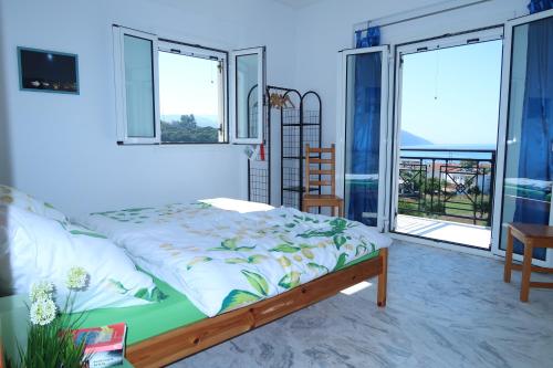 a bedroom with a bed and a balcony at Finikounda in Finikounta