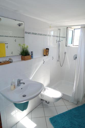 a white bathroom with a sink and a shower at Finikounda in Finikounta