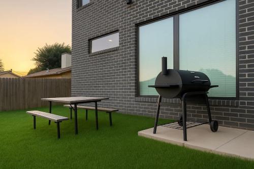 een grill en twee picknicktafels in een tuin bij King Beds Grill Big Yard Huge Kitchen in Oklahoma City