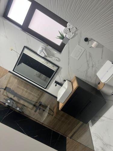 a room with a desk with a television and a window at Uniri Urban Escape in Craiova