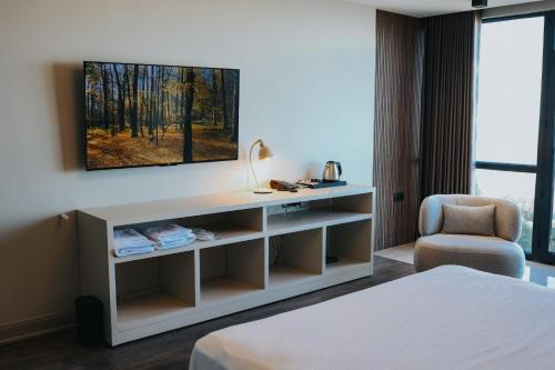 a hotel room with a tv and a chair at Şahin Tepesi Suites I Rize in Rize