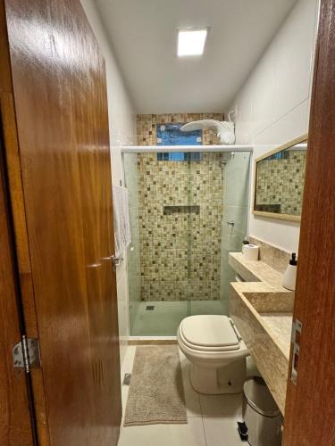 a bathroom with a toilet and a glass shower at Casa Tranquila in Vitória