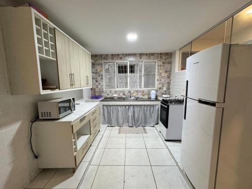una cucina con un frigorifero bianco e un lavello di Casa Tranquila a Vitória