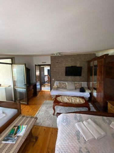 a large room with two beds and a tv at Villa Jadran Apartments in Bar