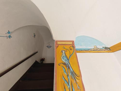 een trap met een schilderij van een pauw aan de muur bij Casa Di Nonna in Cuglieri