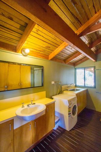 a bathroom with a sink and a washing machine at Bimbimbi • Coastal Hideaway • 2BR 1770 Views in Seventeen Seventy