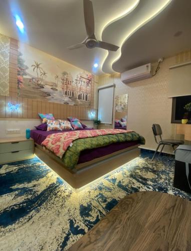 ein Schlafzimmer mit einem Bett und einem Gemälde an der Wand in der Unterkunft SAJ motel 02 in Belgaum