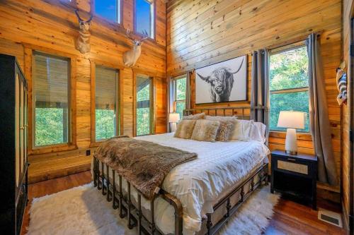 a bedroom with a bed in a room with wooden walls at 5 Bedroom - Four En-Suite & Bunk Loft w/half bath in Stephens Gap