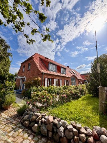 a red brick house with a garden in front of it at Fiskerhytte - Meine Fischerhütte in Börgerende-Rethwisch