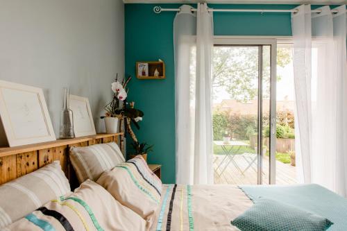 ein Schlafzimmer mit einem Bett und einer grünen Wand in der Unterkunft Chambre d'hôtes - Acrifolia in Aigrefeuille-sur-Maine