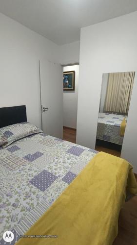 a bedroom with a bed with a quilt on it at Apartamento Aconchegante-1105 in Itatiba