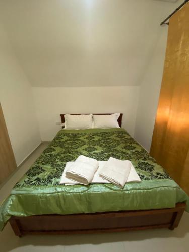 Una cama con dos toallas blancas encima. en Cedar Peak Residence, en Ifrane