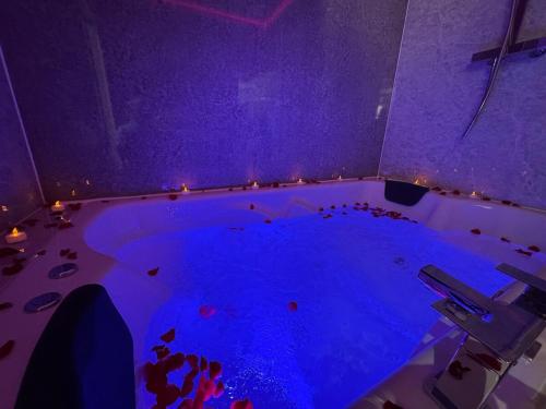 a room with a large tub filled with blue water at Sapphire Dreams in Attercliffe