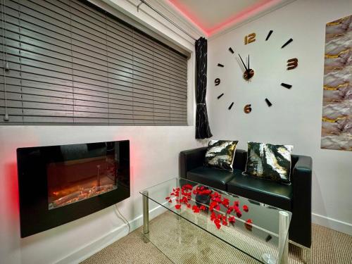 a living room with a clock and a couch and a fireplace at Sapphire Dreams in Attercliffe