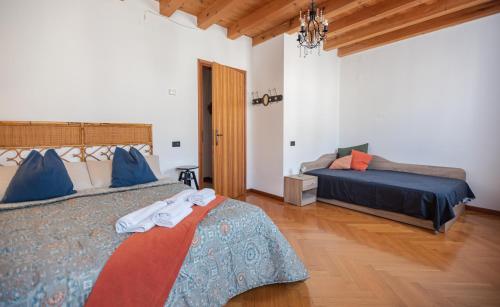a bedroom with two beds and a chandelier at Torre Cà Emo, Il Bilocale "Leone di San Marco" in Vittorio Veneto