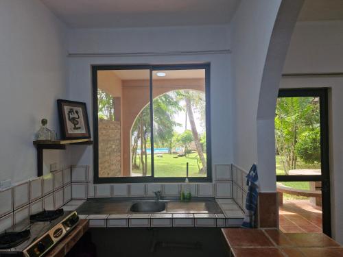 a kitchen with a sink and a large window at El Diamante - Playa Hermosa in Playa Hermosa