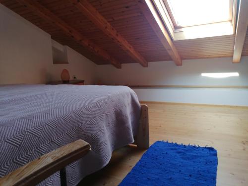 a bedroom with a bed and a window and a blue rug at Apartman Ustrine in Ustrine