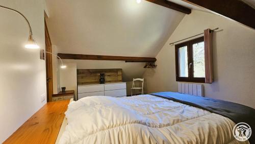 una camera da letto con un letto grande e una finestra di Le fournil a Marcillac-la-Croisille