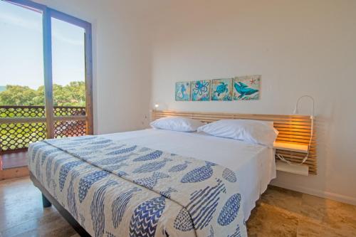 a bedroom with a bed and a large window at Elbamar Lacona in Lacona