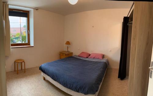 een slaapkamer met een bed met een blauw dekbed en een raam bij Concorde in Besançon