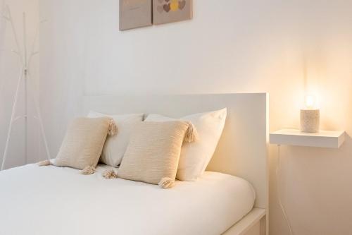 - un lit blanc avec des oreillers blancs dans l'établissement GuestReady - Modern Comfort in Almada, à Almada