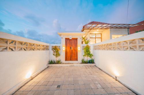 a house with a wooden door in a courtyard at Villa Gadang in Kerobokan