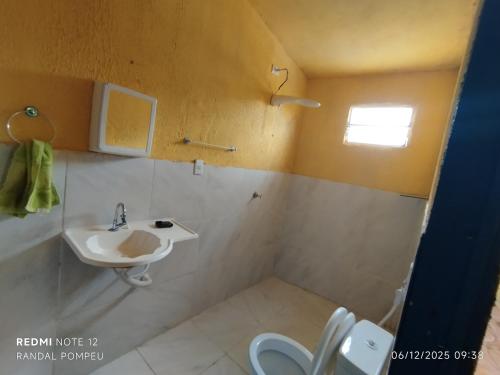 een badkamer met een wastafel en een toilet bij Chalé nas Nuvens in Sobral