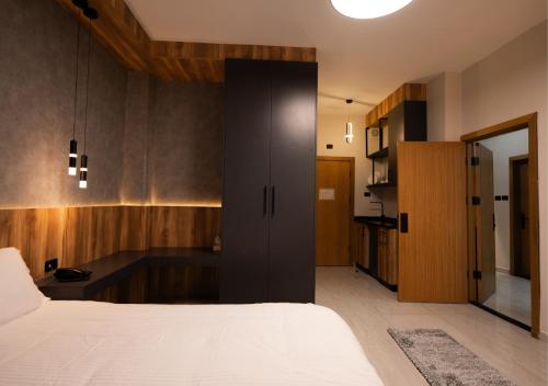 a bedroom with a large bed and wooden cabinets at Al Jawhara Hotel Suites in Amman