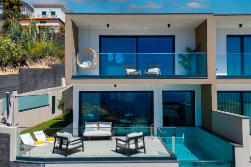 a house with a swimming pool and two chairs at Villa Nero by LovelyStay in Funchal