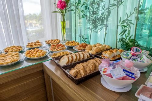 un buffet avec de nombreux types de pains et de viennoiseries dans l'établissement Porto da Serra Hotel, à Gravatá
