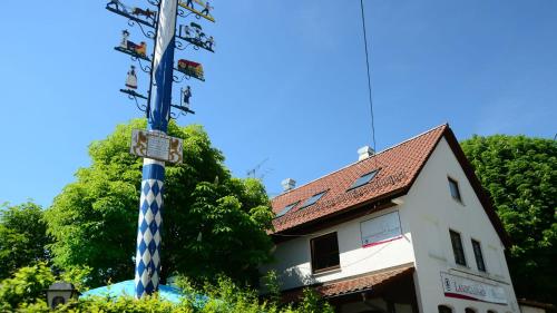 un palo blu e bianco di fronte a un edificio di Landgasthof Haller a Gauting