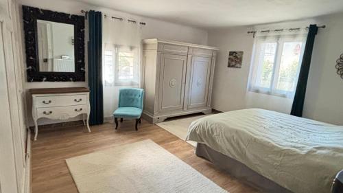 Un dormitorio con una cama, una cómoda y un espejo. en Sous Le Tilleul - 3 personnes, en Valréas