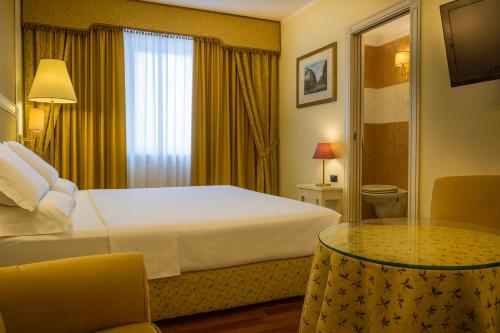 a hotel room with a bed and a glass table at LVG Hotel Collection - La Bussola in Novara