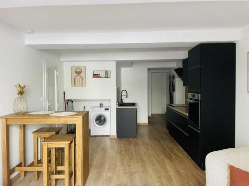 una cucina e un soggiorno con tavolo e forno a microonde di Studio Bohème a La Côte-Saint-André