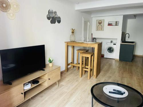 un soggiorno con una TV a schermo piatto su un tavolo di Studio Bohème a La Côte-Saint-André