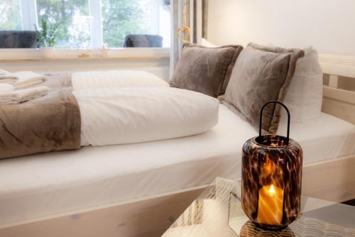 - une chambre dotée d'un lit avec une bougie sur une table dans l'établissement Harzliebe, à Sankt-Andreasberg