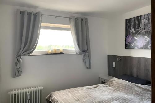 une chambre avec un lit et une fenêtre dans l'établissement Geißenblick, à Hohegeiss